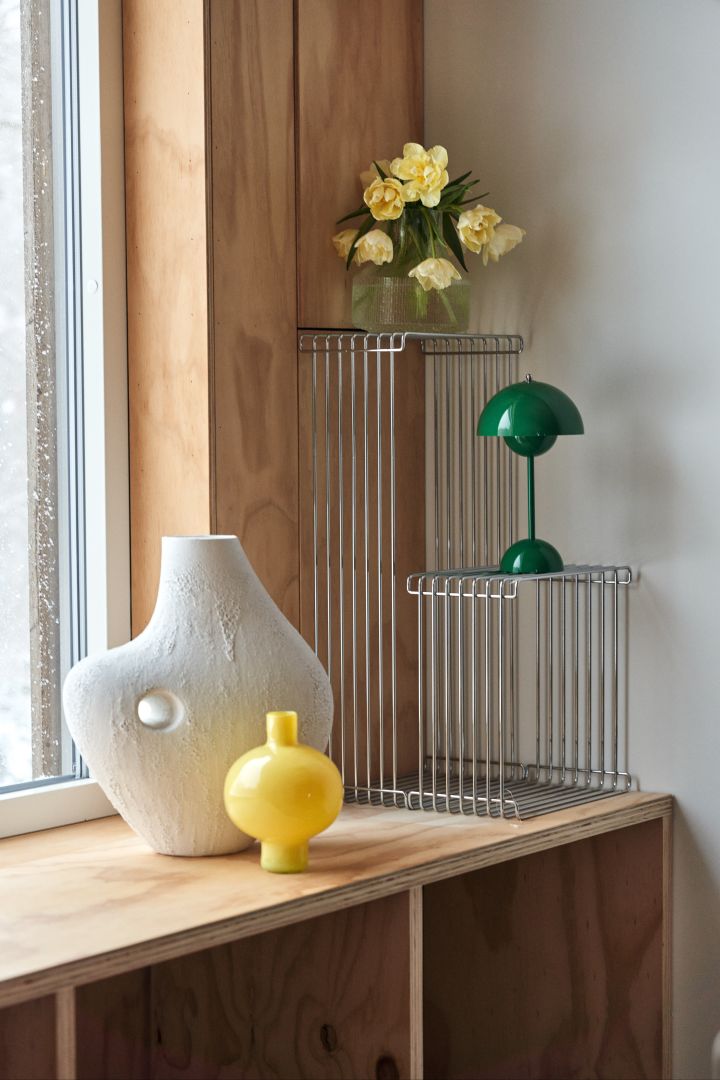 Decorating with statement details is in line with the spring 2024 interior design trends, here Talvi vase from Urban Nature Culture together with Panton Wire modules and Flowerpot VP9 in green.