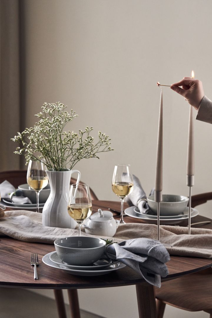 Here you see an elegant table setting idea created with Swedish Grace plates and bowls in the colour Mist with beige candles from Ester and Erik. 