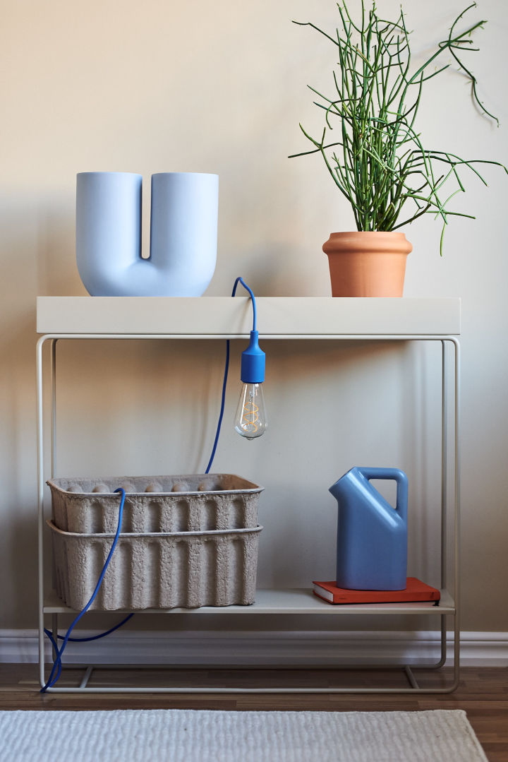 Colorful interior style in soft blue tones and beige in the form of a console table from Ferm Living and a vase from Muuto.