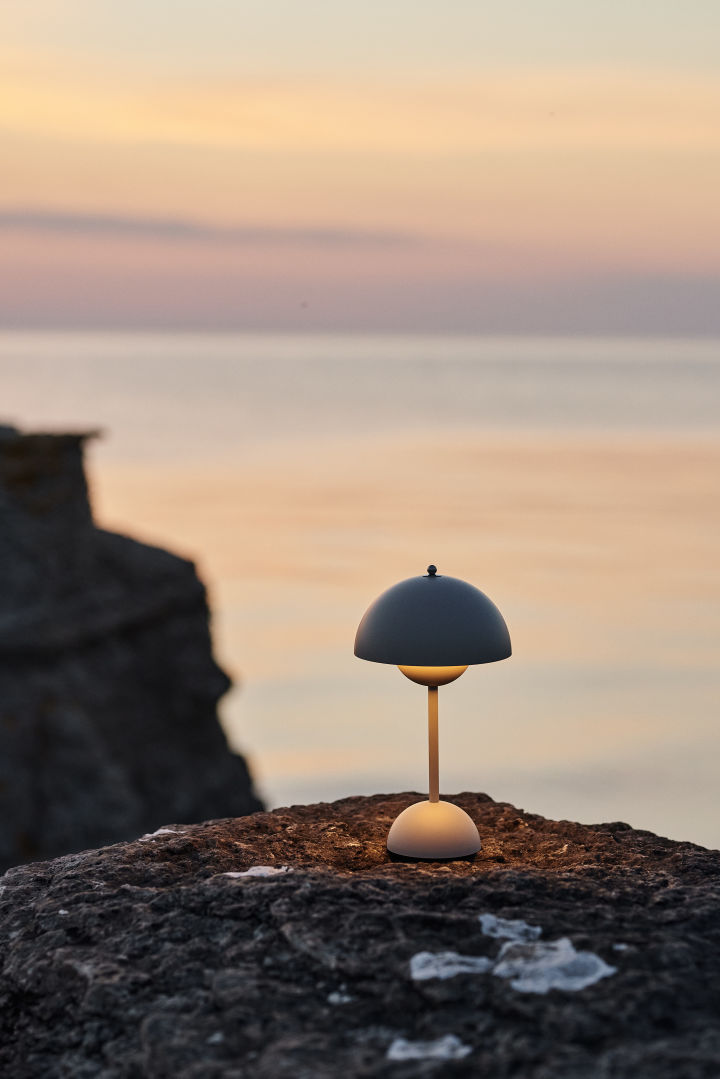 The Flowerpot cordless lamp from &Tradition sitting on the rocks on the beach is a summer essential you do not want to miss out on. 