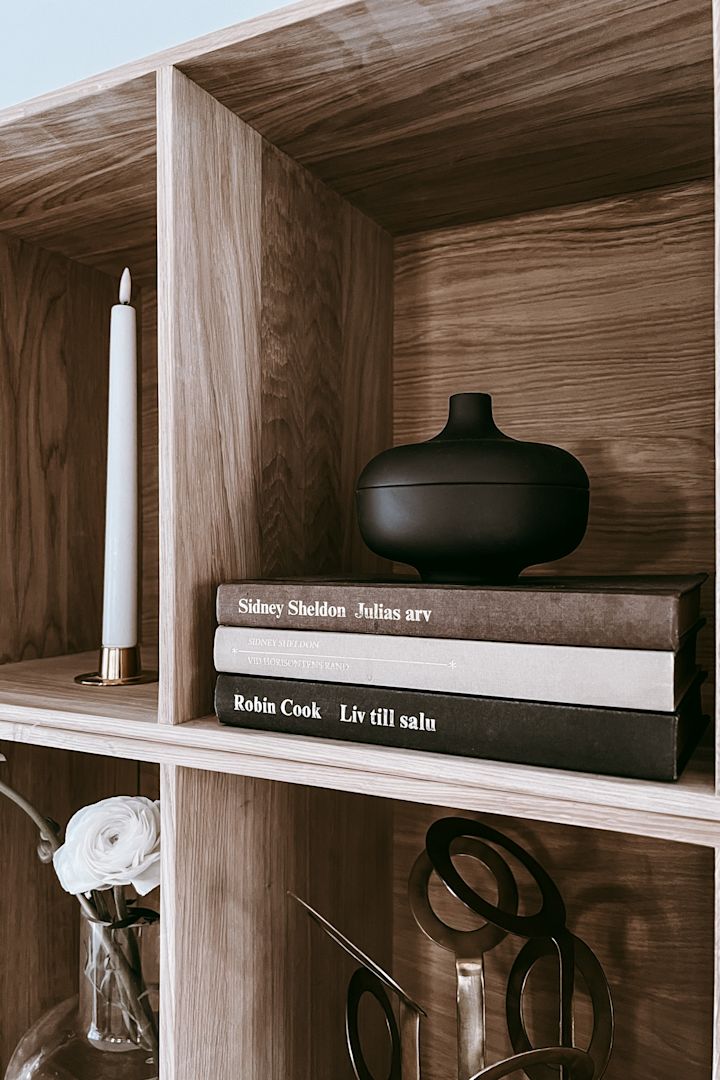 Bookshelf decor ideas - inspiration at Anela Tahirovic's home @arkihem where a bowl from Design House Stockholm is placed on a stack of books to create height. 