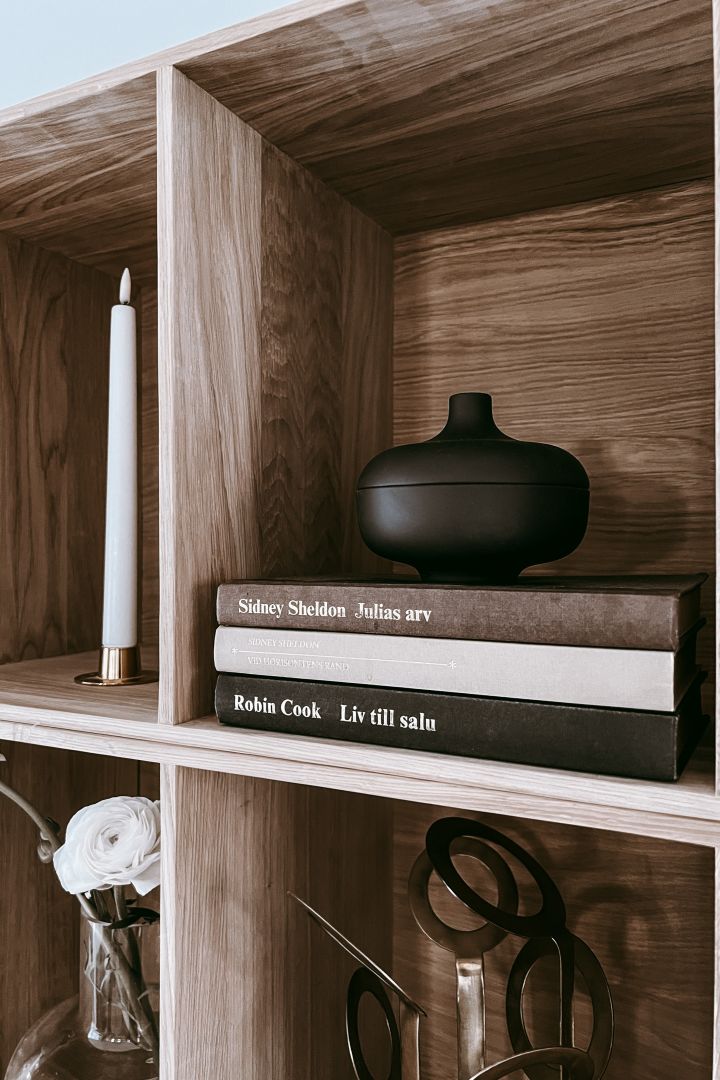 Bookshelf decor ideas - inspiration at Anela Tahirovic's home @arkihem where a bowl from Design House Stockholm is placed on a stack of books to create height. 