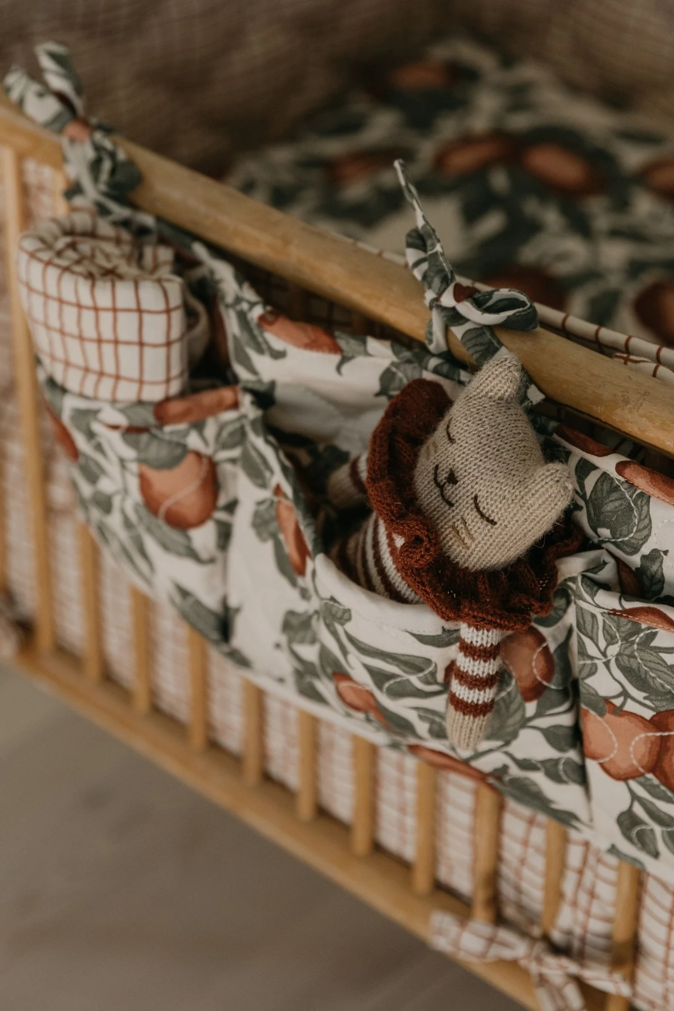 The Garbo&Friends crib pocket hangs on the side of a cot filled with all the things a new parent needs to soothe an unhappy baby - an ideal baby shower gift idea. 