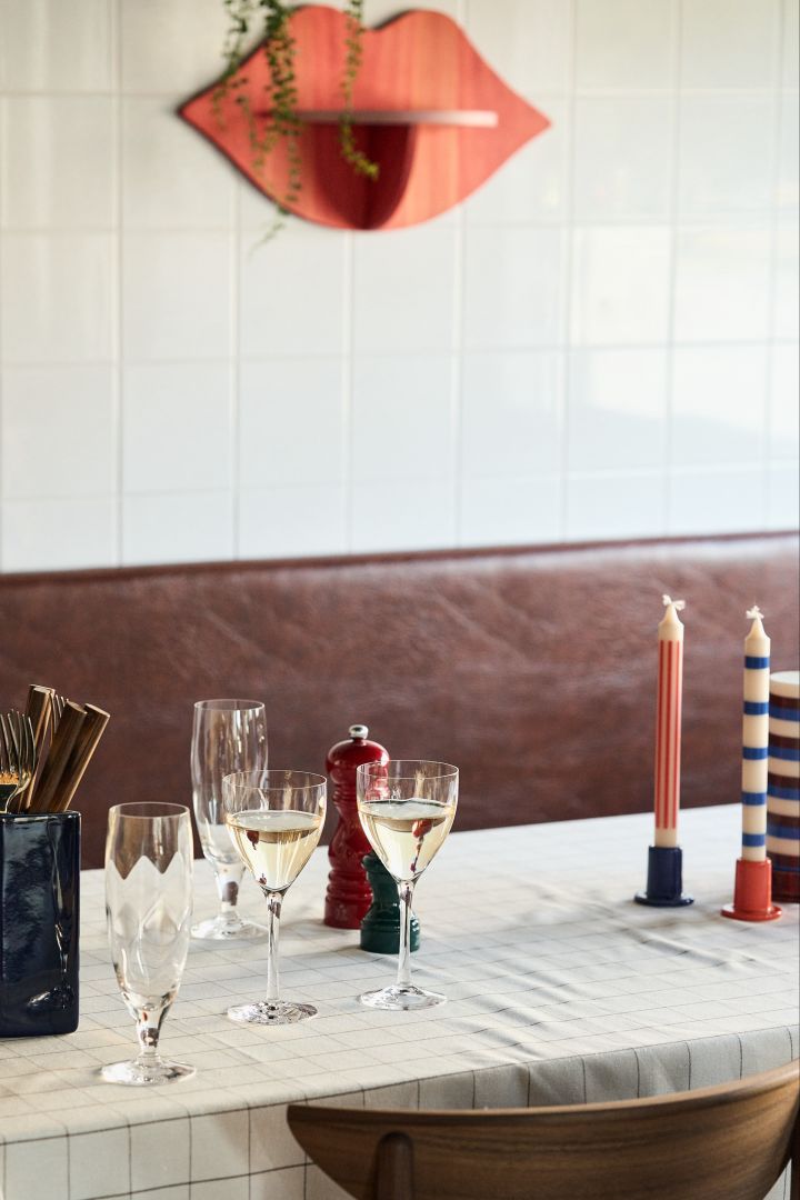 The Chateau white wine glasses from Kosta Boda on a set table with colourful HAY candlesticks on the table. 