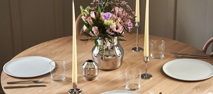 The new collection for Gense designed by Monica Förster, here you see the two polished stainless-steel vase and candle sticks in a simple table setting.