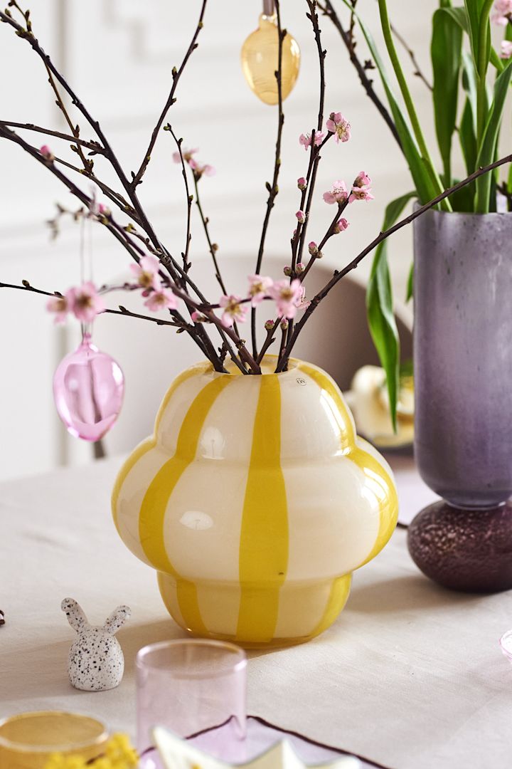 Create a festive Easter table setting in spring pastels with Iittala's colourful glass eggs in a beautiful Easter branch that is in the Curlie vase from By On.