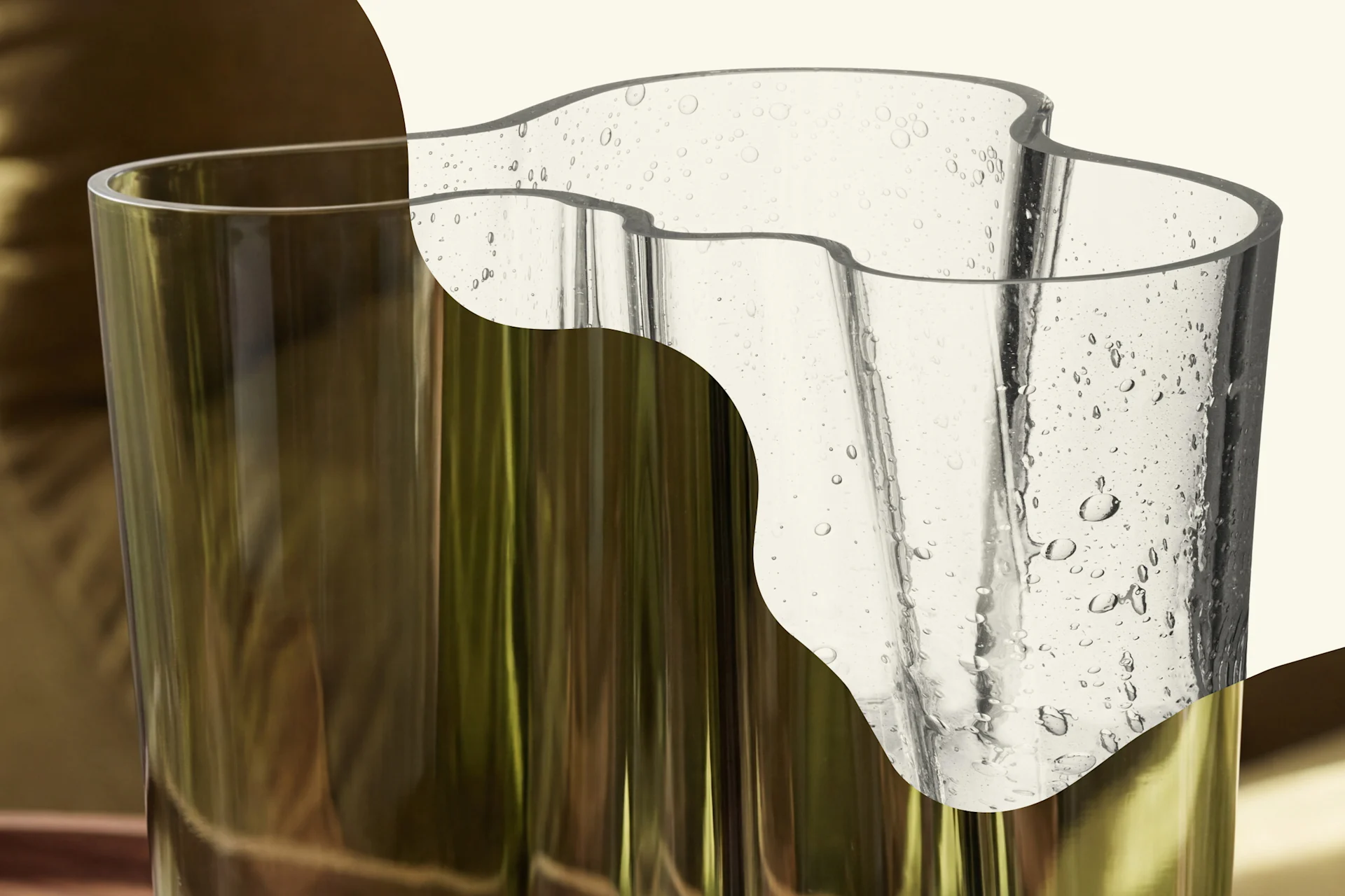 Two glass vases: one olive green cylinder, one clear and wavy with air bubbles.