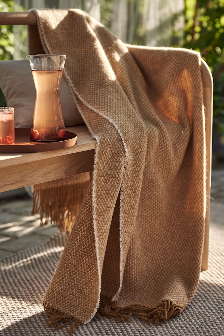 Cosy patio decor ideas - Create a cosy patio by decorating your patio soft textiles such as Scandi Living's wool plaid in a lovely shade of orange.