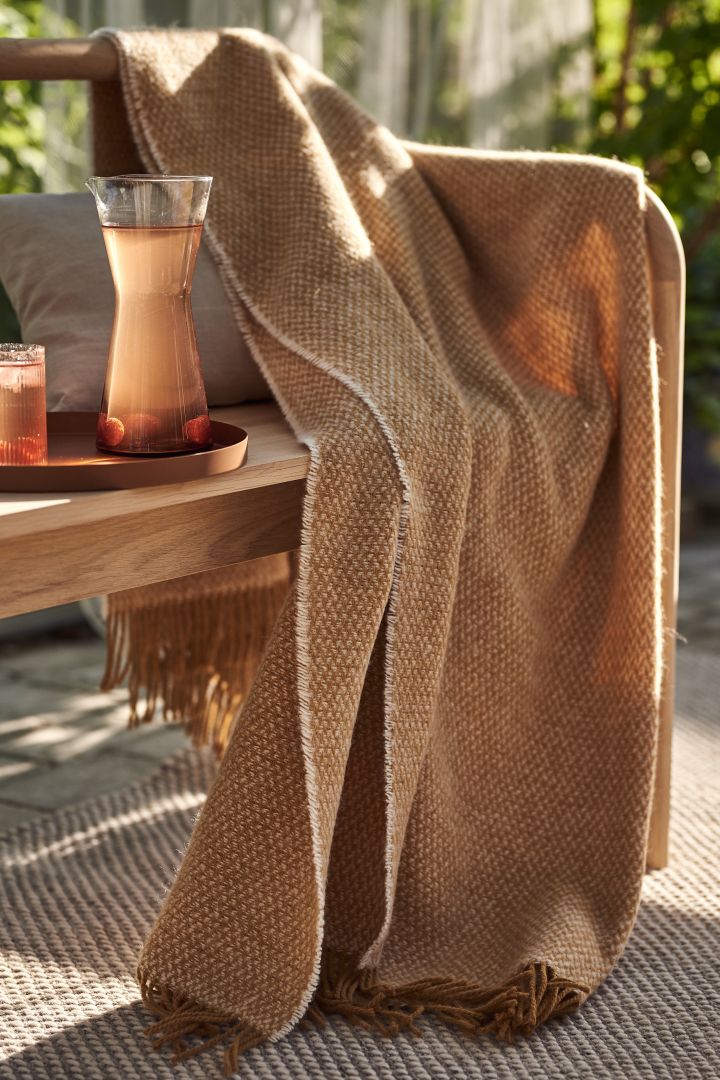 Cosy patio decor ideas - Create a cosy patio by decorating your patio soft textiles such as Scandi Living's wool plaid in a lovely shade of orange.