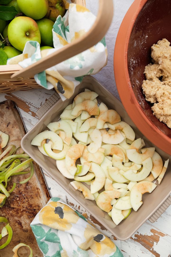Picture showing Flora oven dish in beige with handle from Sagaform, here filled with apple slices for an apple pie. Next to it is a Knabstrup dough dish.