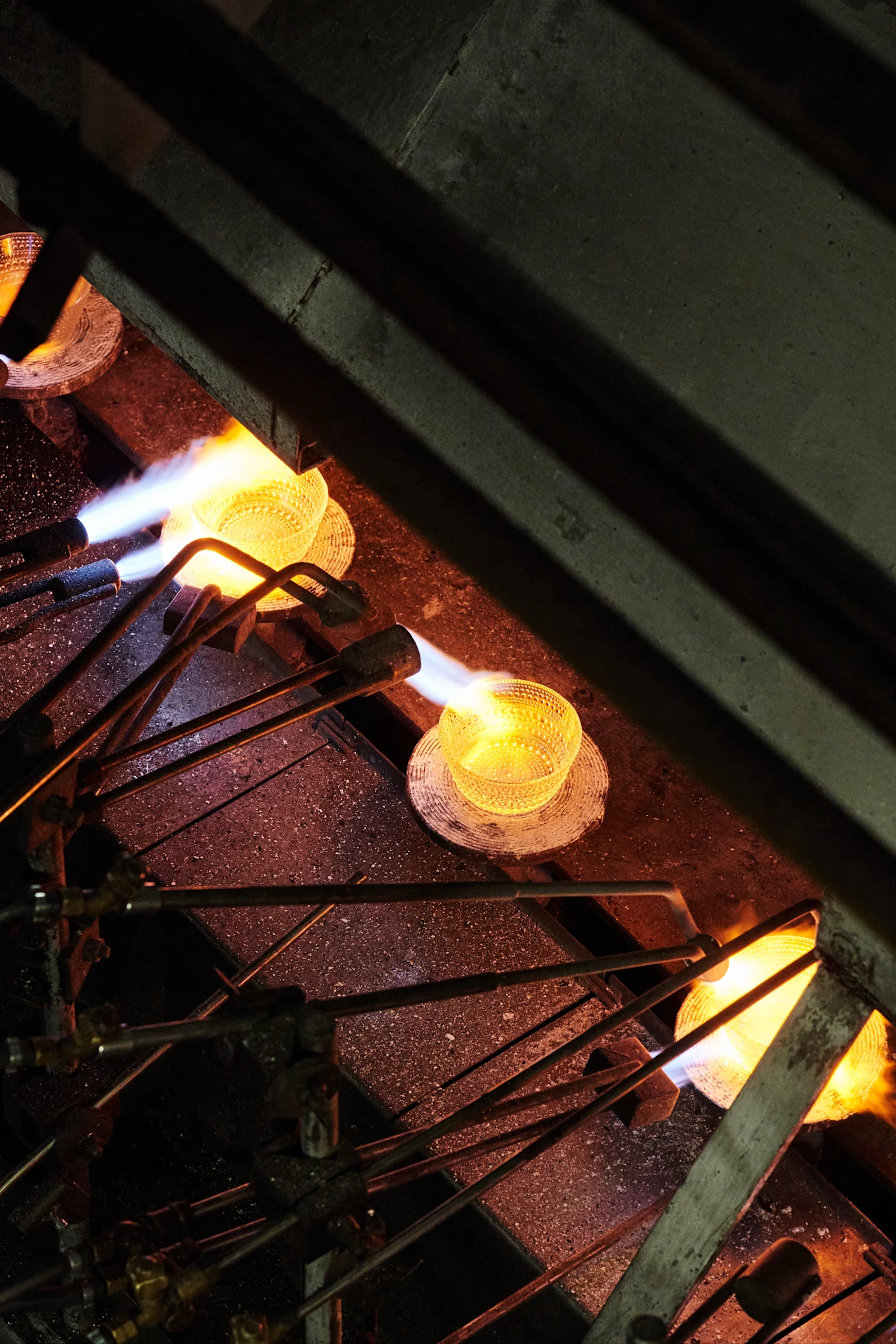 The Kastehelmi bowl is heated in a production line in the Iittala's glassworks in Finland. 