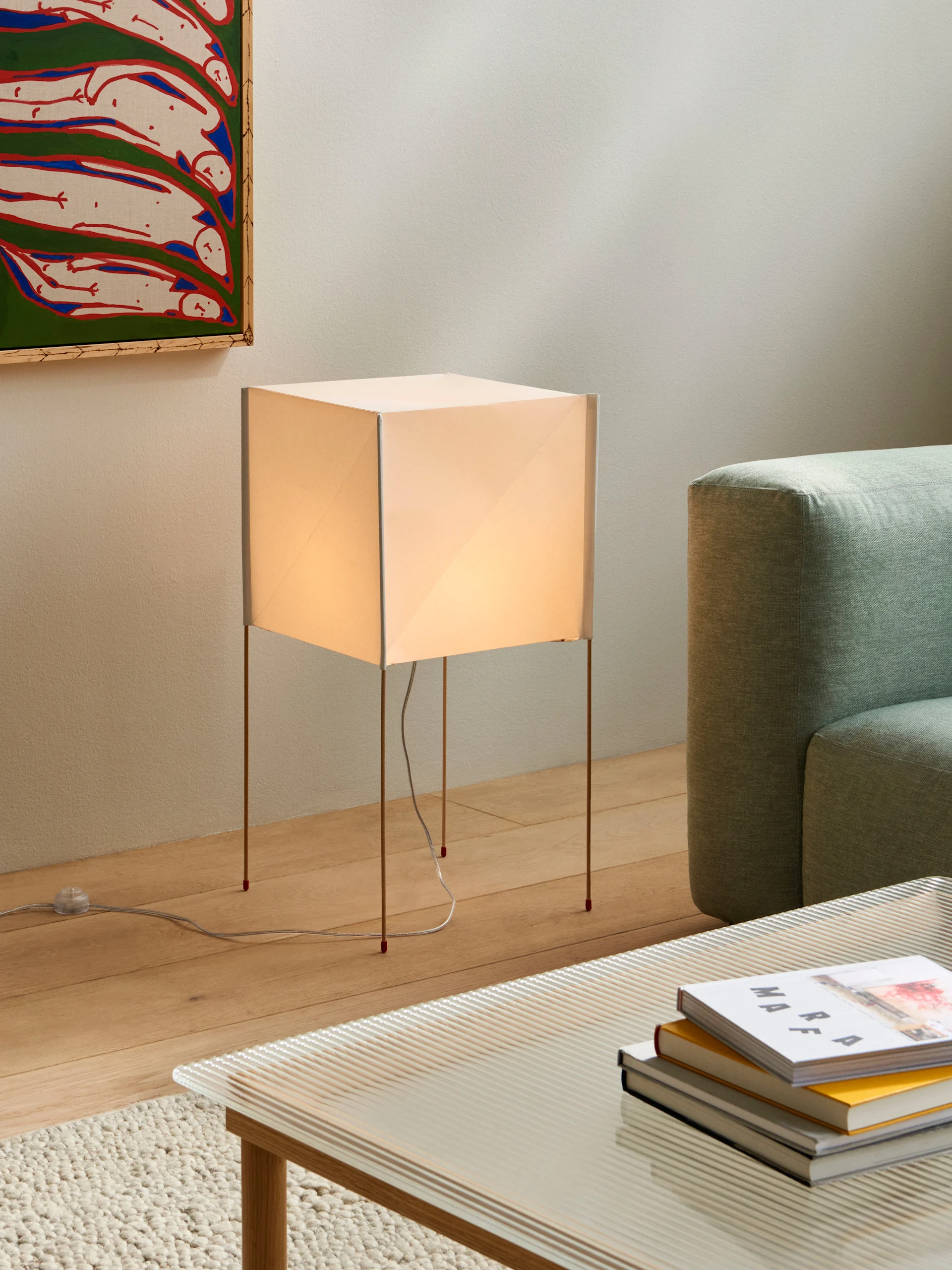 Lamps with paper shades are on trend in autumn 2025. Here, the square Paper Cube floor lamp from Hay stands in a living room.