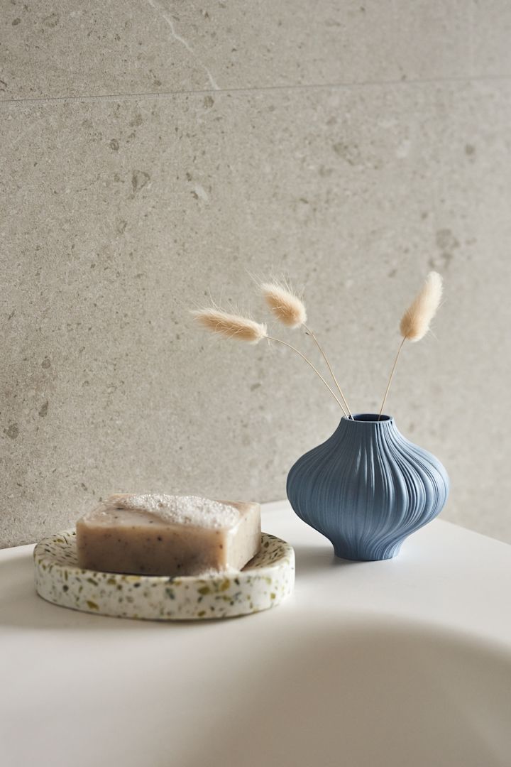 Scandinavian interior design trends for 2023 are taking inspiration from water and the sea. Here you see the mini vase Plisse in light blue in the bathroom. 