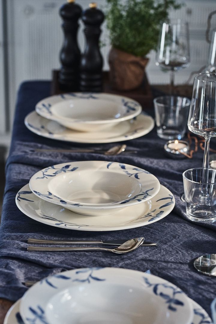 A blue and white summer table setting with porcelain Havspil from Scandi Living and blue linen tablecloth as a base.