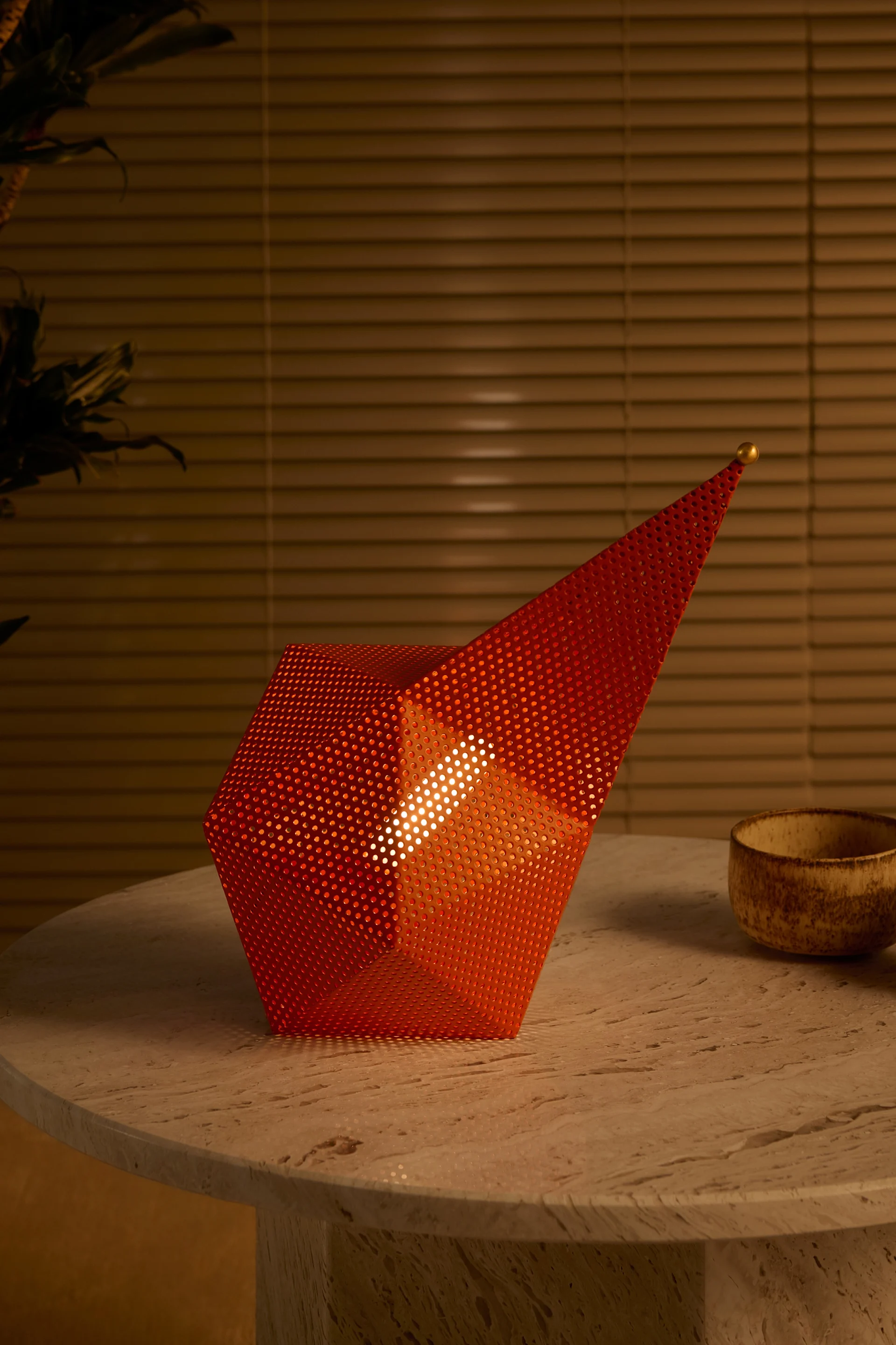 The 60s and 70s are revived with the autumn interior design trends 2025: here, the orange portable table lamp from Gubi stands on a wooden table.