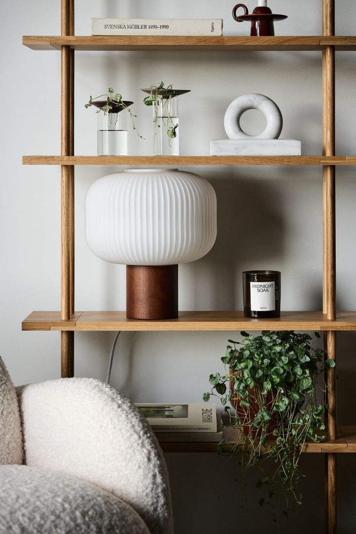 Walnut and dark woods such as dark stained oak are trending in 2024 interiors. Here, the Fair table lamp from Scandi Living with a ribbed diffuser and lamp base in dark stained ash. 