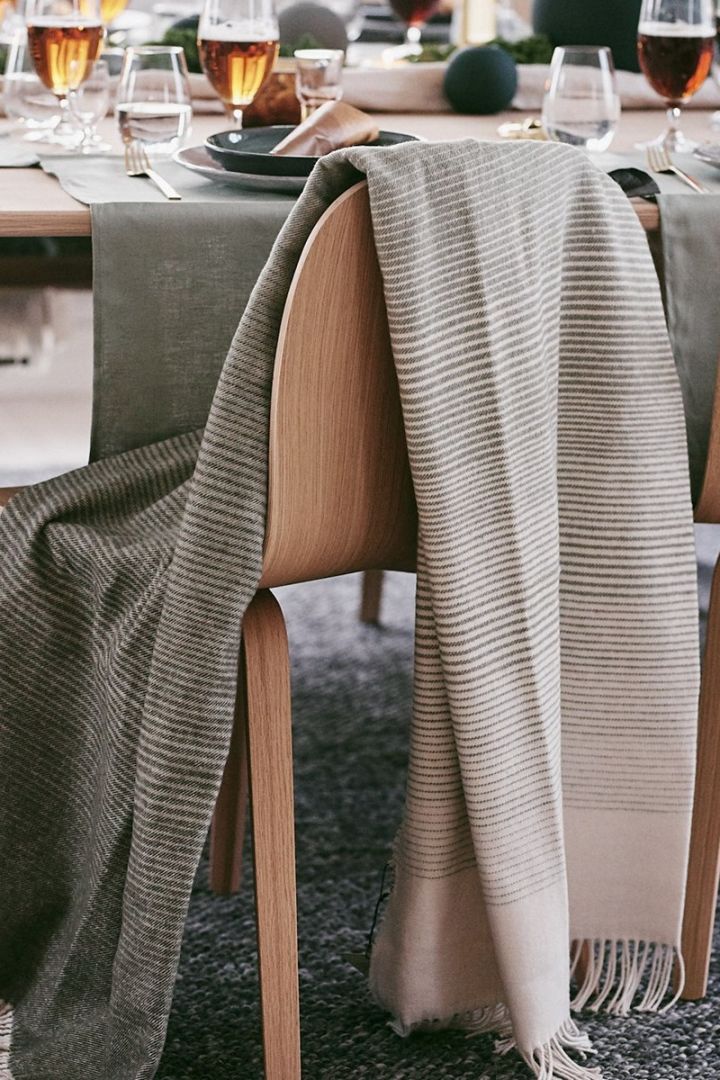 Here you see the forest green Mist Throw from Scandi Living draped over a dining room chair.  
