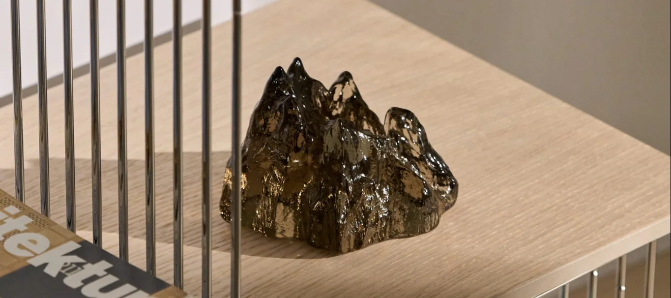 A close-up of the brown The Rock candle holder by Kosta Boda on a Panton Wire shelf.