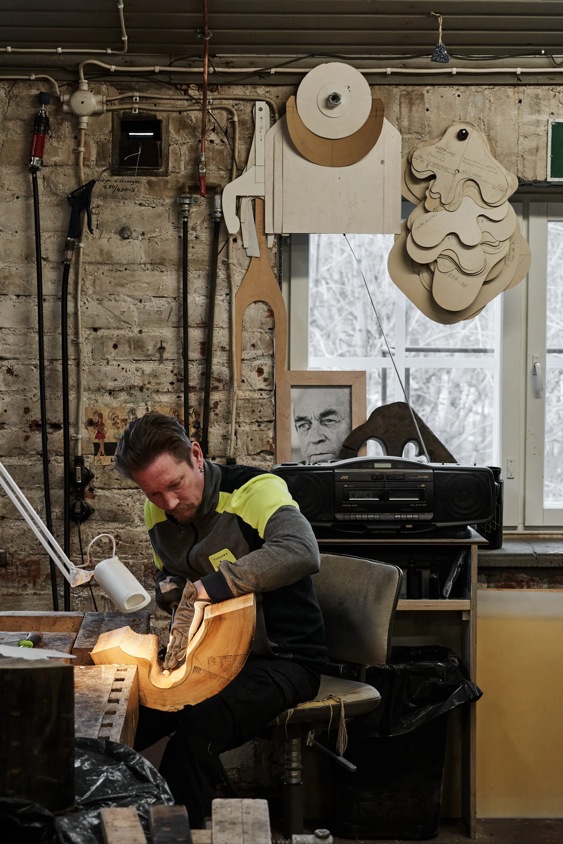 A man carves a wooden mould to be used to create the Alvar Aalto vase.