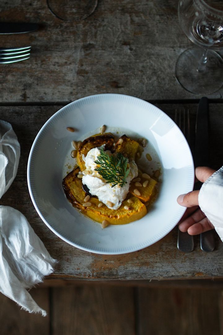 A hand places the Osean plate from Wik & Walsøe on a table. 