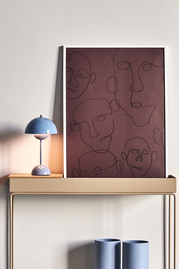 17 stylish Scandinavian wall posters to give your walls an update - here you see the graphic Audience poster from Paper Collective that represent several black graphic faces against a dark brown base.