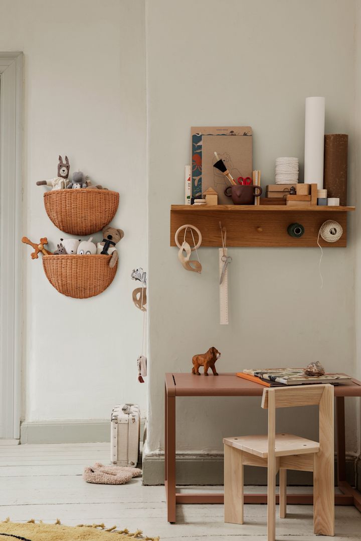 Discover how to declutter your home. Here you see the Ferm Living baskets and hooks with shelf hanging on the wall in a children's bedroom. 
