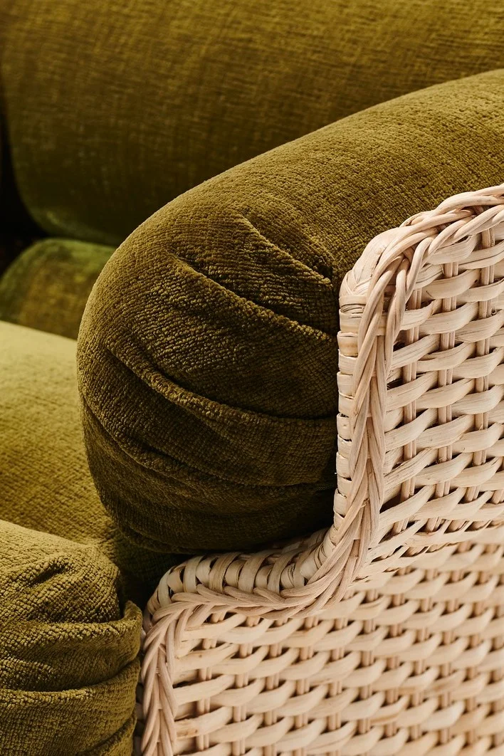 Chunky furniture is the trend in autumn 2025. The wicker chair from Gubi consists of a rattan body and thick green cushions.