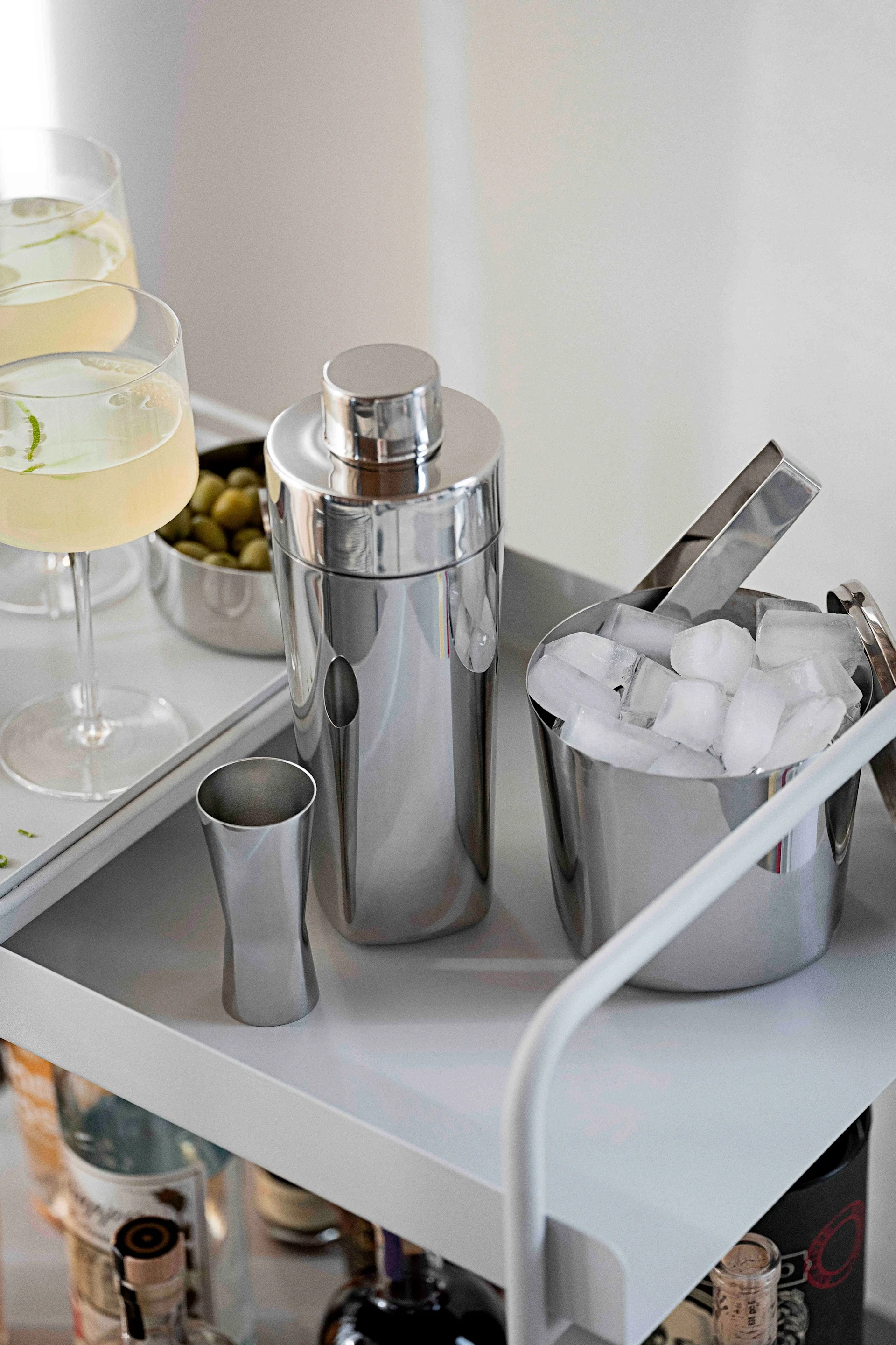 Professional cocktail accessories are also recommended for mocktails. Here, the shaker, measuring cup and ice bucket from the Rocks collection by Zone Denmark stand on a bar trolley.
