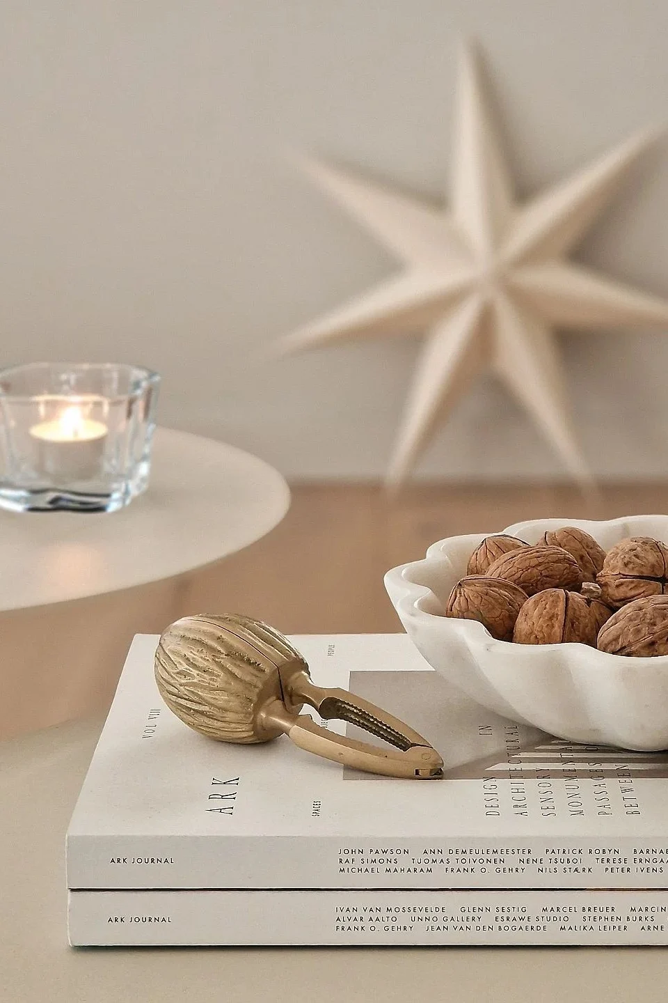 Minimalist Christmas decor is about decluttering. Here you see a bowl filled with walnuts and a brass nut cracker from Ferm Living. 