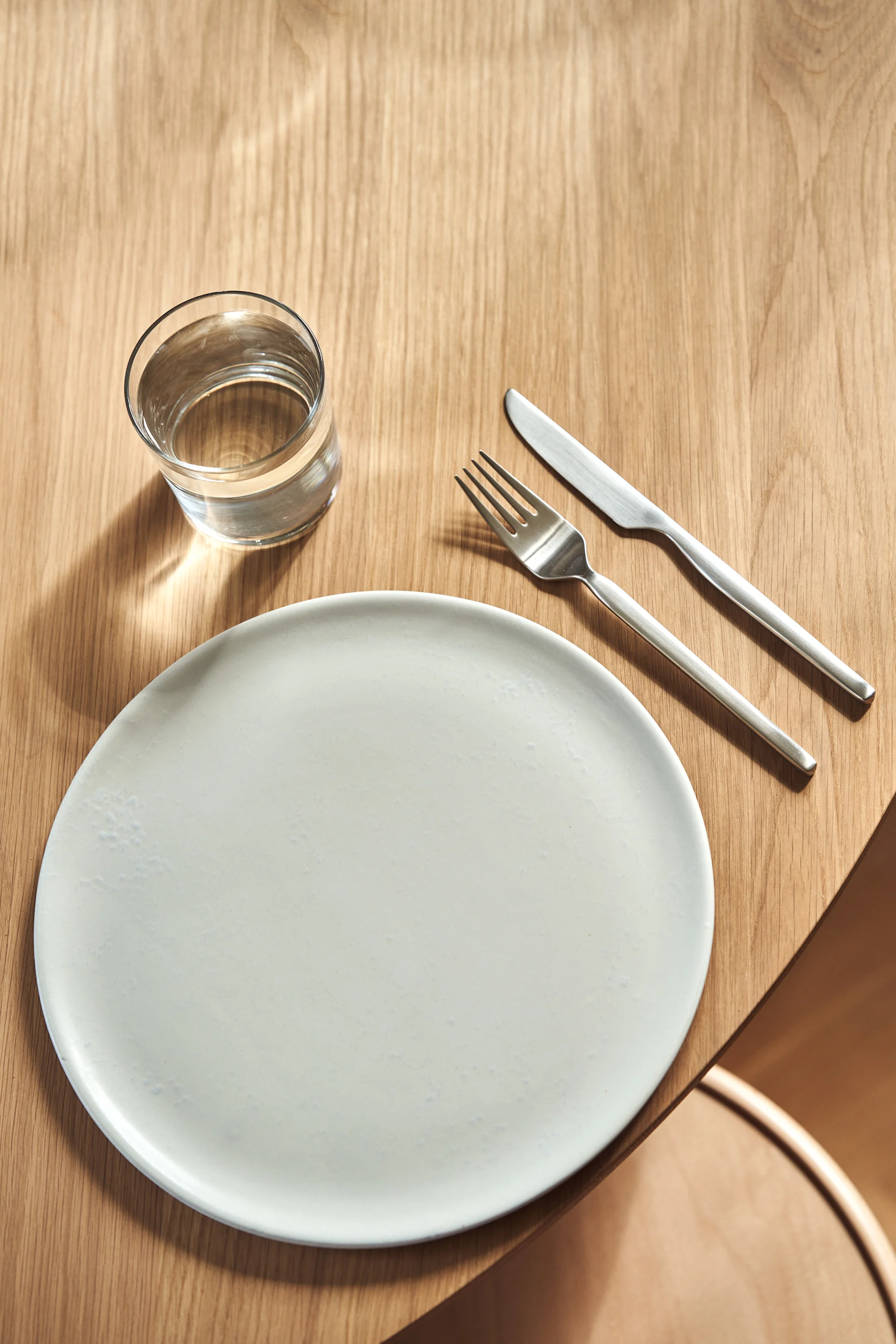 An overhead shot of the Dorotea cutlery for Gense with a simple white plate. 