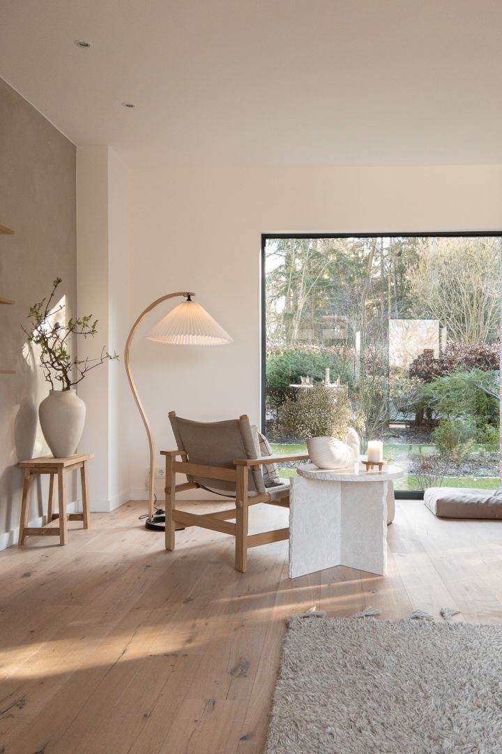 Create a Scandinavian home - here you see the living room from @haus_tannenkamp with the curved Gubi lamp and the white Mineral table from Ferm Living. 