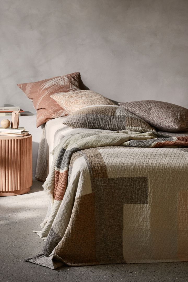 Quilted patterns are some of the interior design trends for spring 2022 that look great mixed and matched with different types of textiles such as Patch bedspread from Broste Copenhagen.