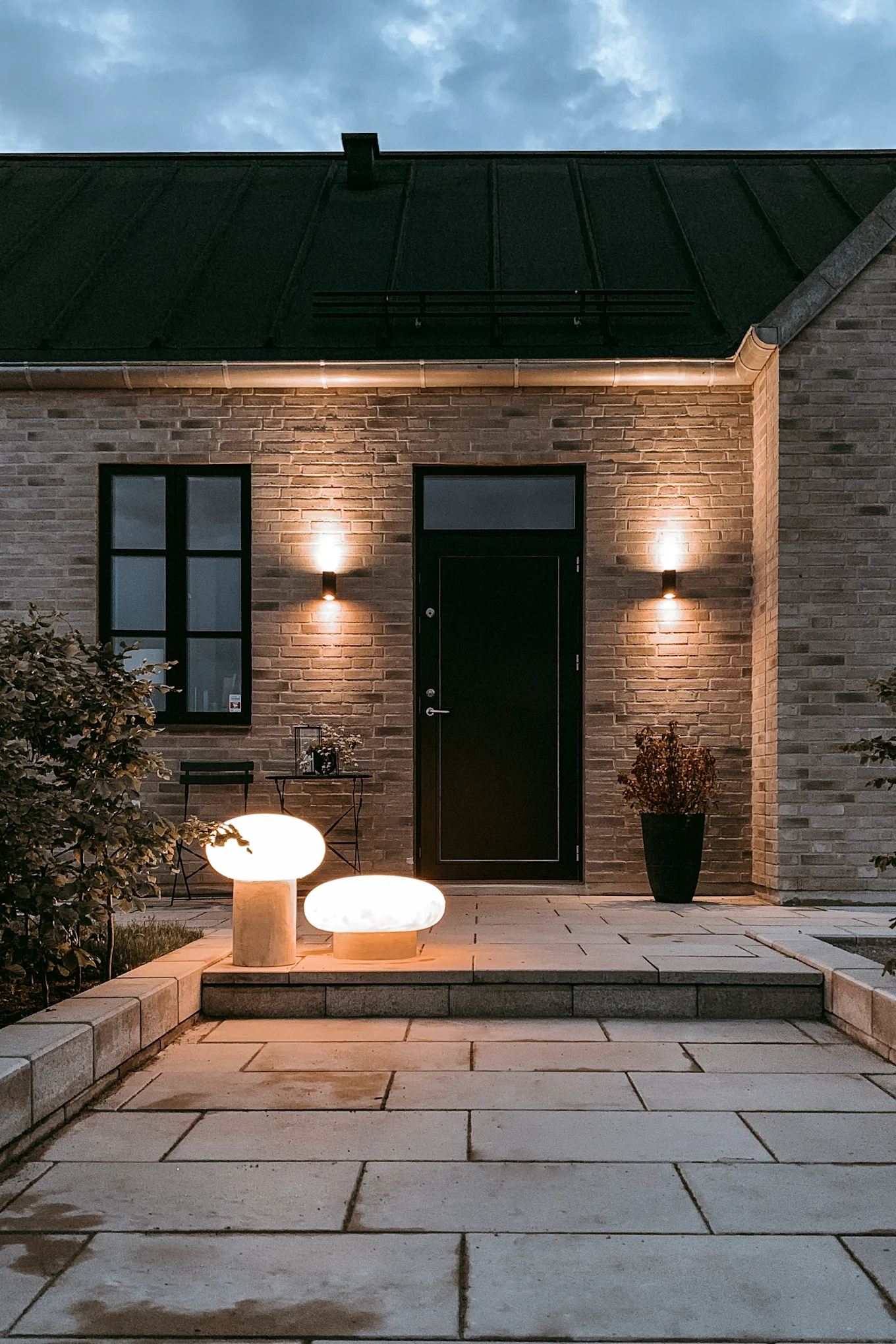 A house entrance illuminated with the Umfors free-standing luminaires from Globen Lighting in two sizes.