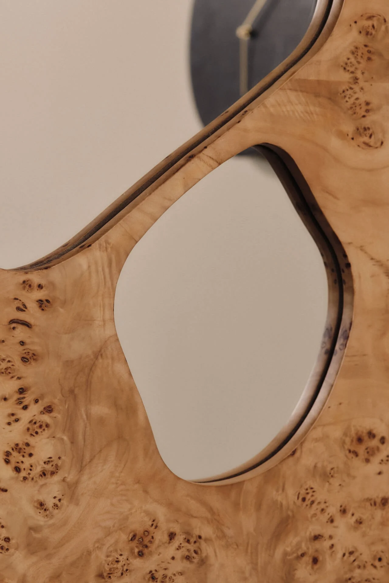 Close-up of a light burl wood panel with a large, curved cutout, showcasing its unique grain.
