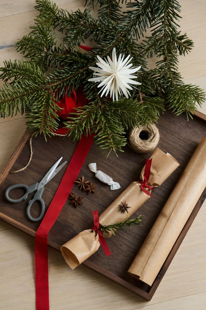 To make your own Christmas crackers you will need, scissors, paper, toilet rolls, candy, small gifts, decorations and string.