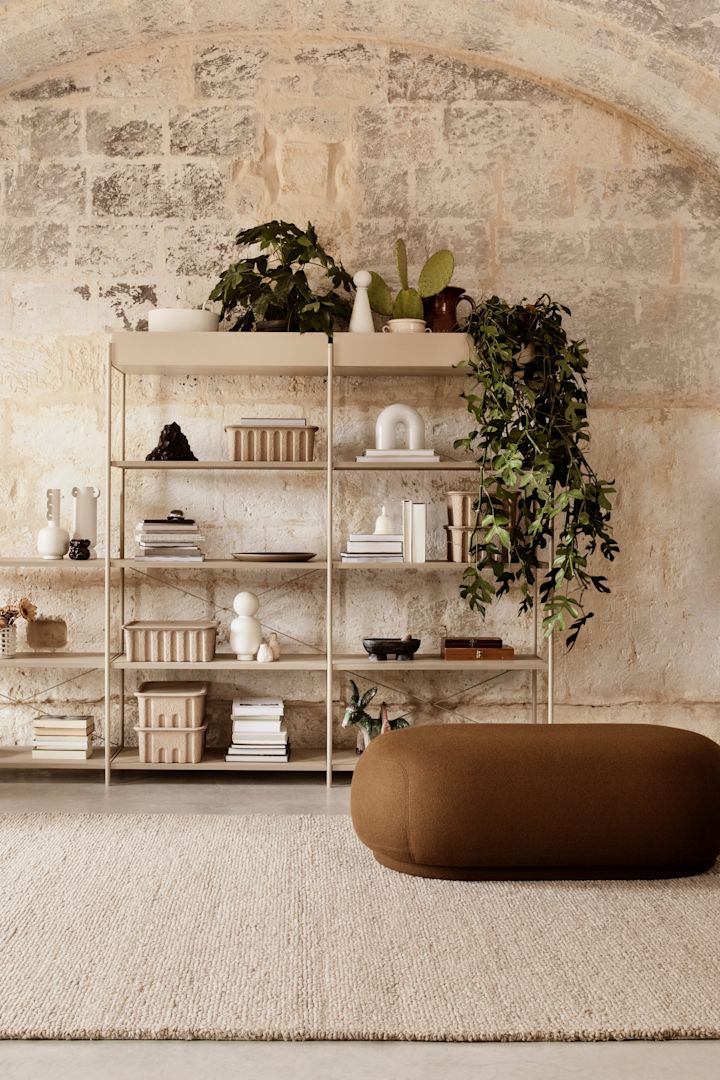 Nice living room at Ferm Living with bookshelf in beige and pouf in 