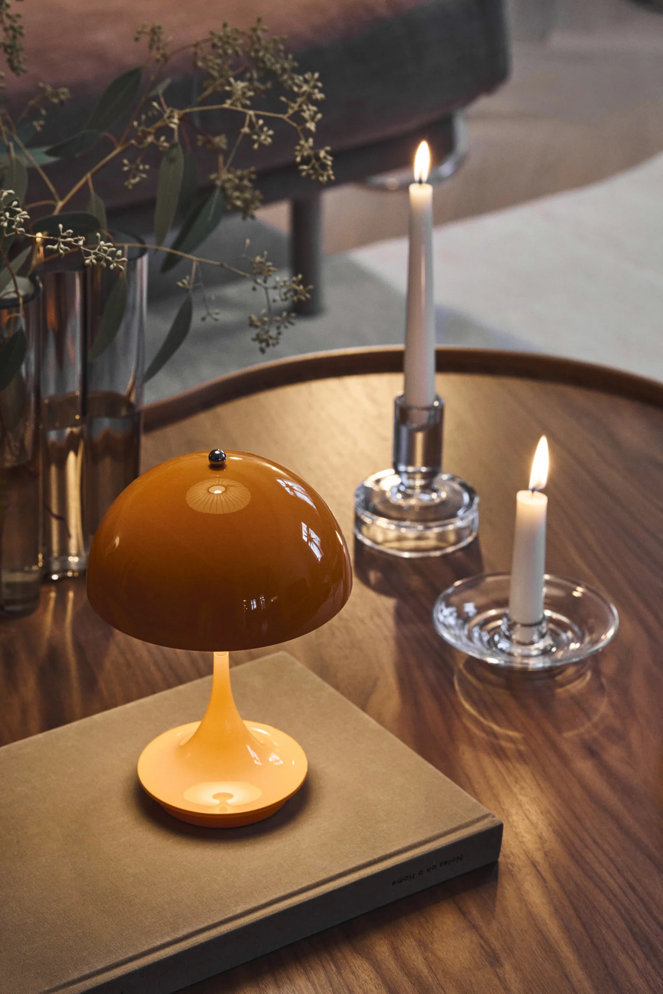 Orange is part of the colour trends for 2026, shown here as a Panthella lamp on a living room table alongside glass candle holders.