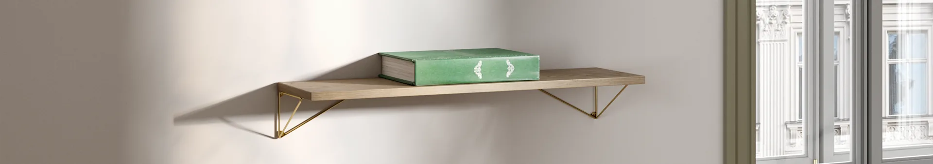 A green book rests on a wooden shelf with golden brackets, illuminated by natural light near a window.
