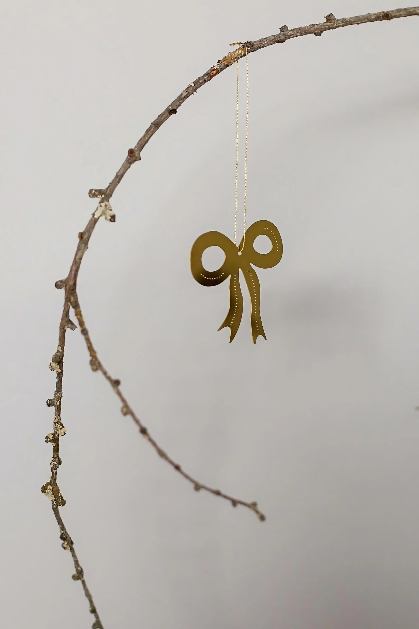 Christmas decorations 2025: The golden Missia decorative pendant by Lene Bjerre hangs on a wall.