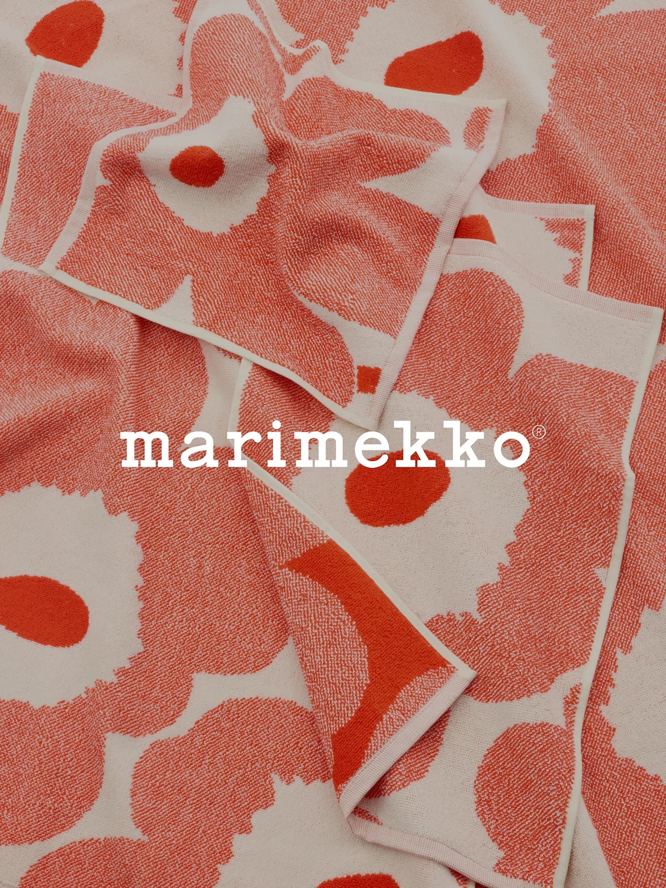 Folded coral and off-white patterned towels with Marimekko logo.