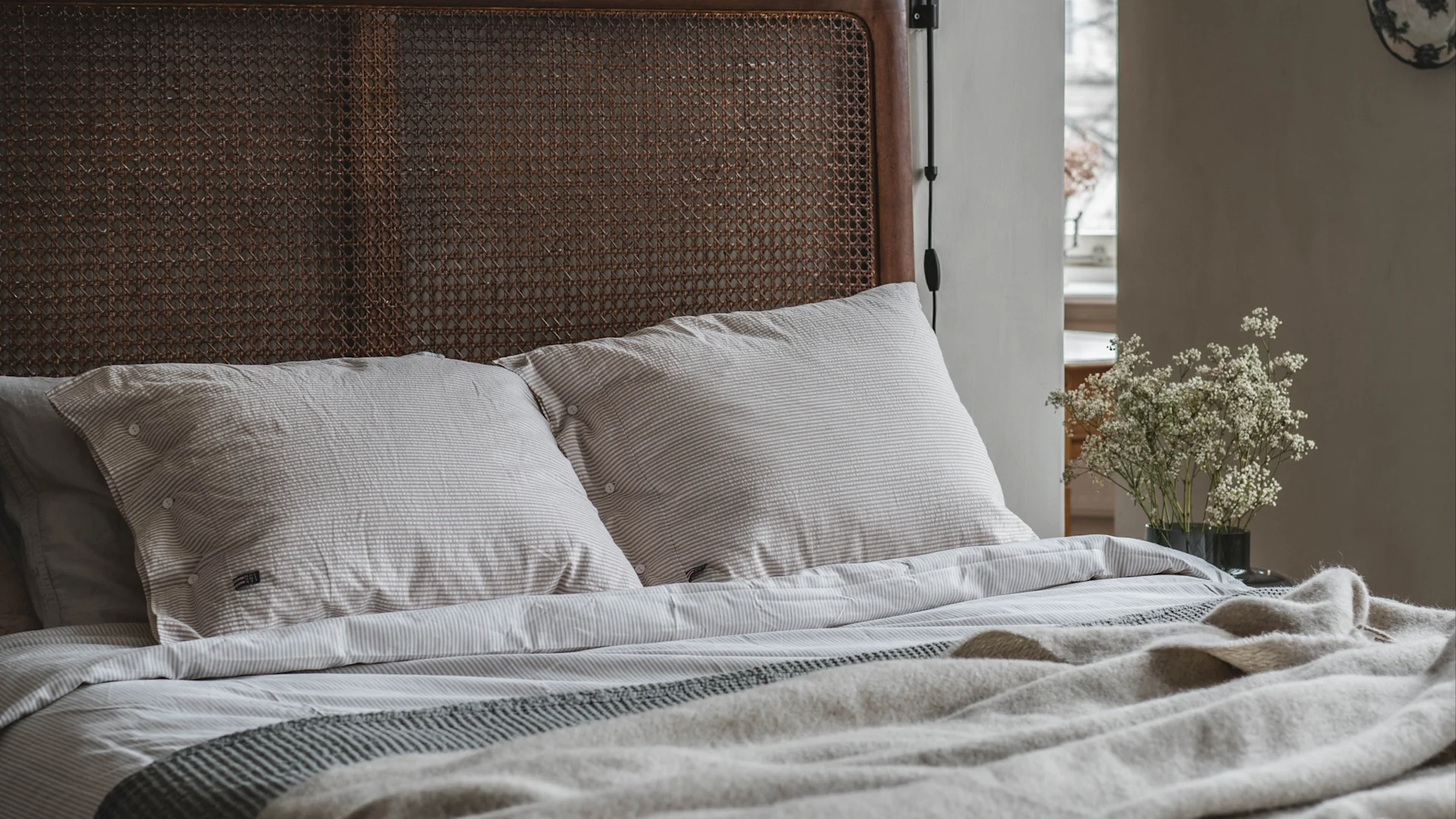 A soft inviting bed in a cosy, calming bedroom-