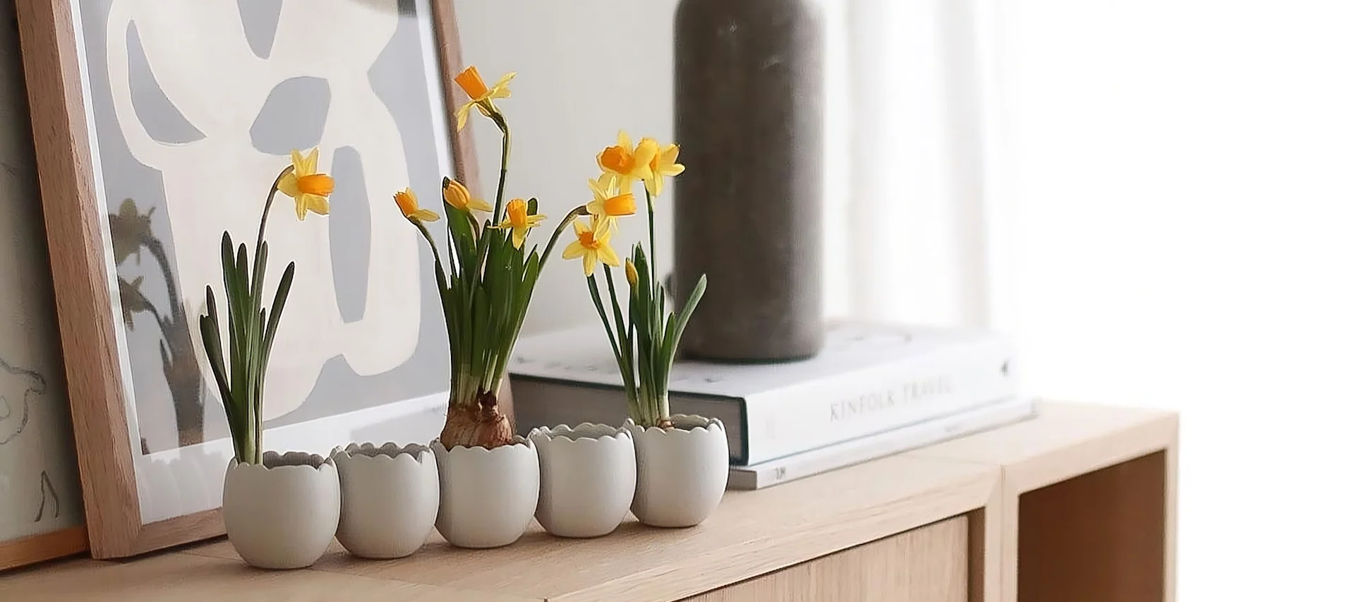 Two ball vases in different shapes and sizes from Cooee Design with spring flowers stand on a tray, next to several triplets of Easter bunnies from DBKD in @sachi_roooom's home.