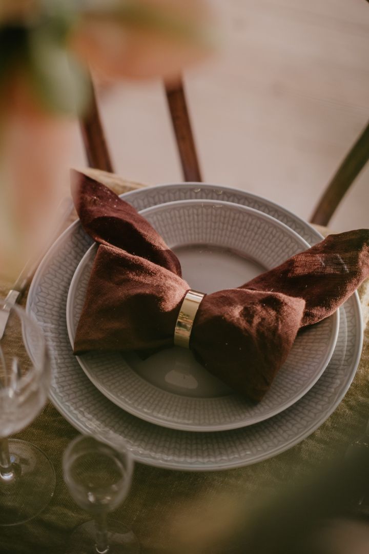 Here you see a brown linen napkin folded into a bow.