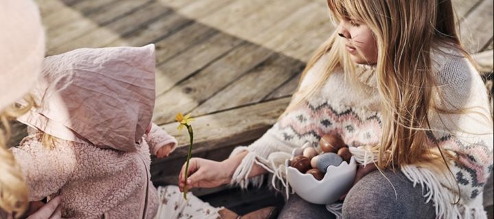 How to organise an egg hunt at Easter - two children enjoy a bowl of easter goodies! 