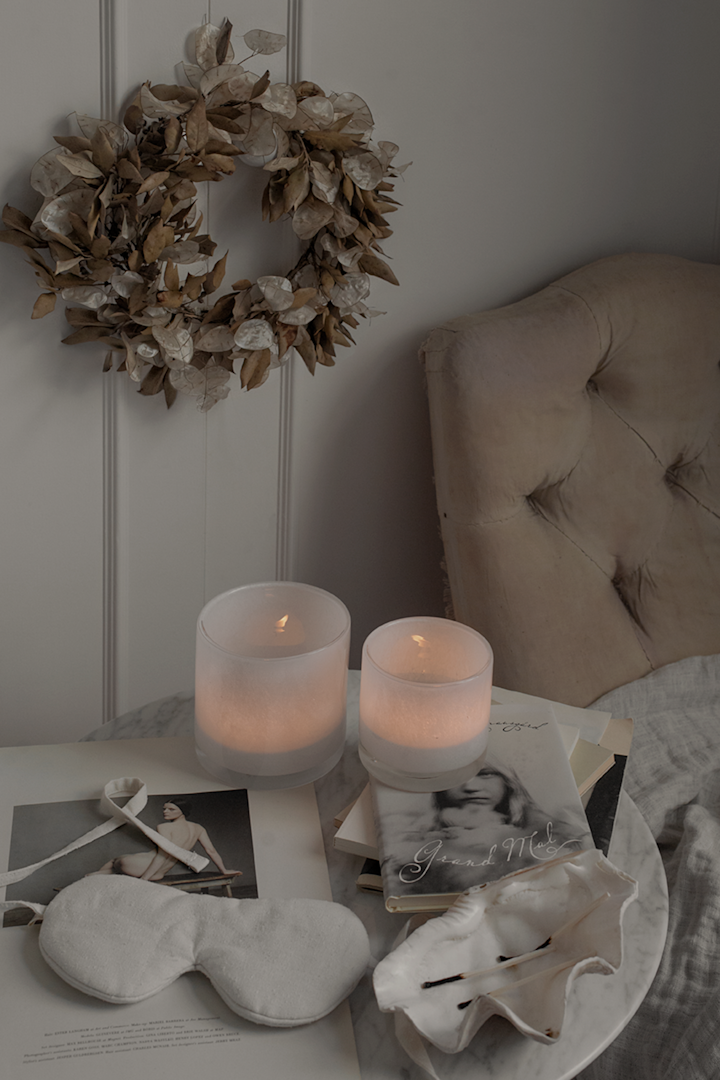 The Nilla lanterns from Olsson and Jensen with lit candles inside on a marble table. 