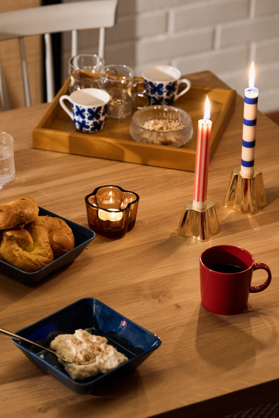 Vintage red and blue Teema mugs and bowls sit beside the striped red and blue candles from HAY part of the vintage Christmas decor.