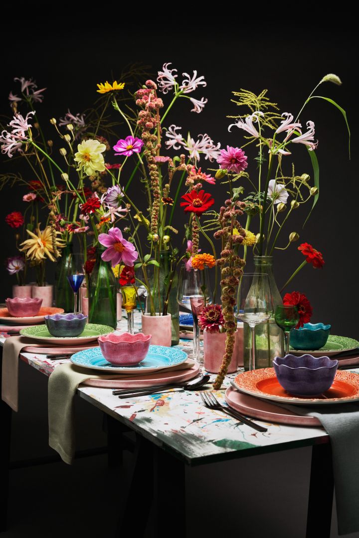Throw a dinner party with your friends and family and decorate with a bright and colourful table setting which is one of the interior design trends for autumn 2022  