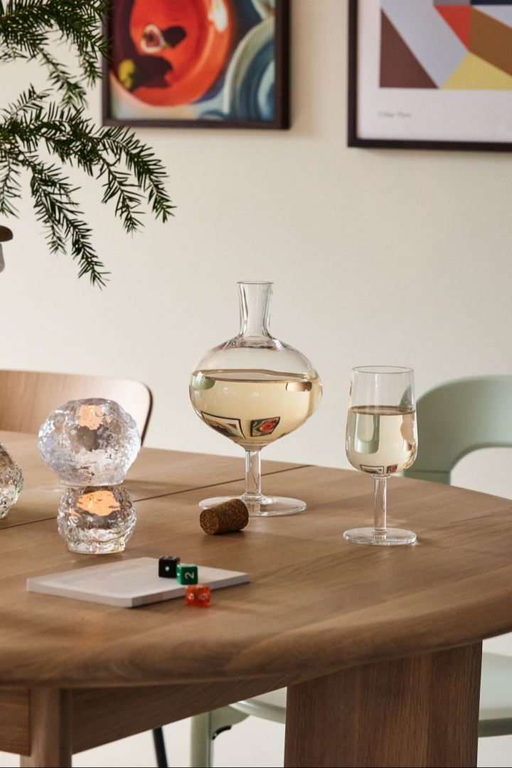 The Bod carafe stands next to a wine glass from Kosta Boda, retro glasses as part of vintage Christmas decor. 