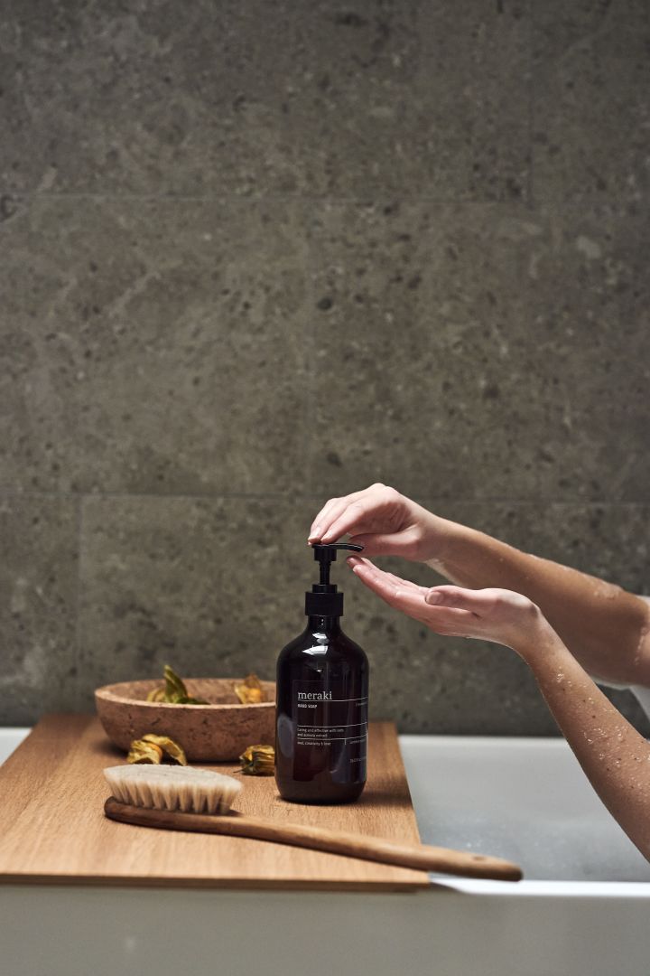 Hands pump the meraki hand soap in a bath as part of a home spa night. 