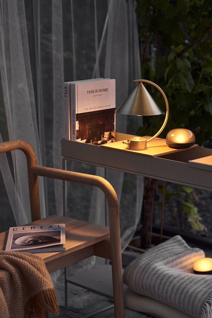 A reading corner is one of the autumn interior design trends in 2021. Here is the Meridian portable lamp in brass from Ferm Living.